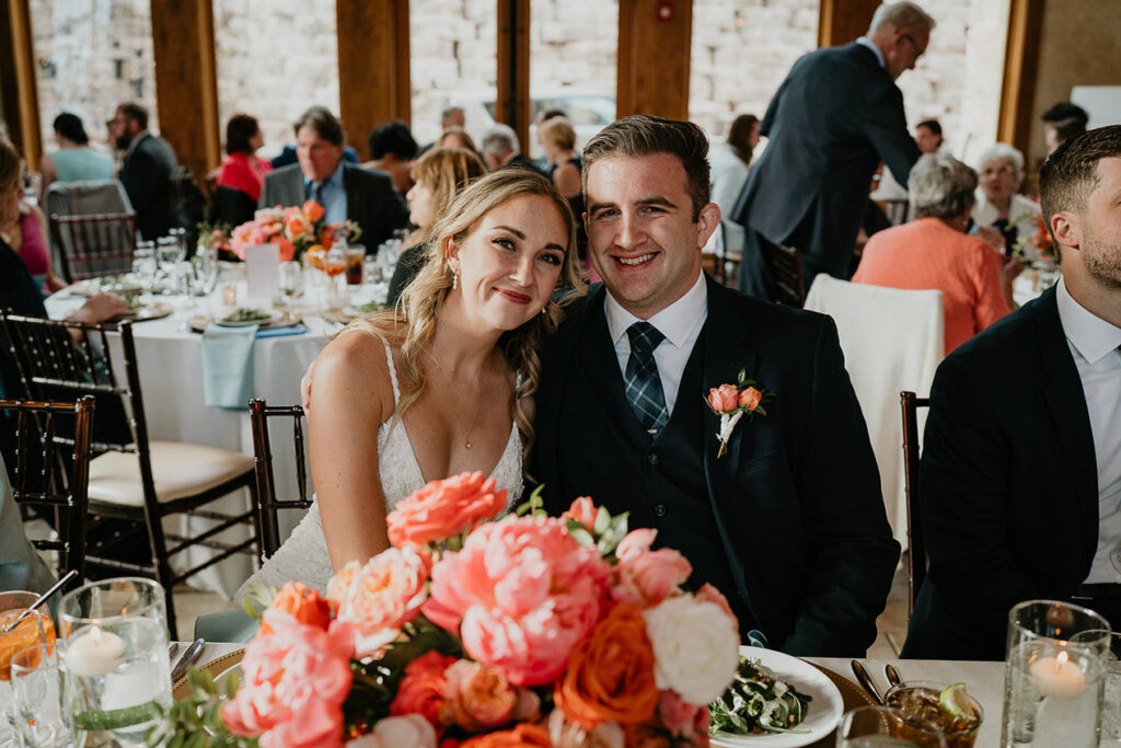 The bride and groom smiling during their Estes Park Wedding dinner.