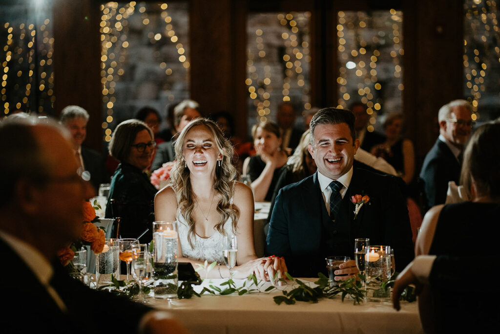 The bride and groom laughing with friends and family. 