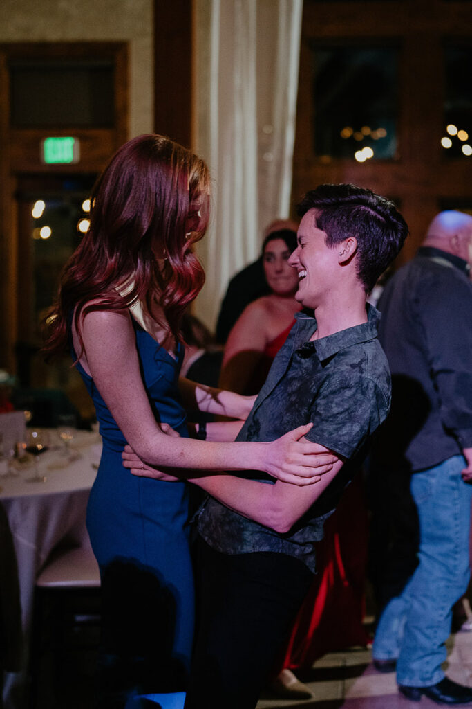 Two wedding guests smiling and dancing.