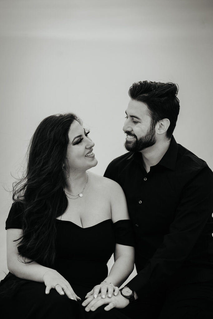 A black and white photo of a couple looking lovingly into each other's eyes. 