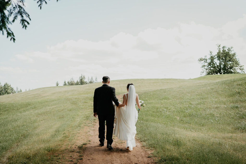 Judith and Joshua walking along a grassy trail at Oregon Golf Club. 