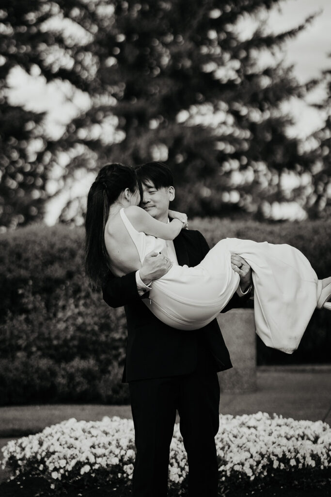 A black and white image of Joshua holding Judith in his arms. 