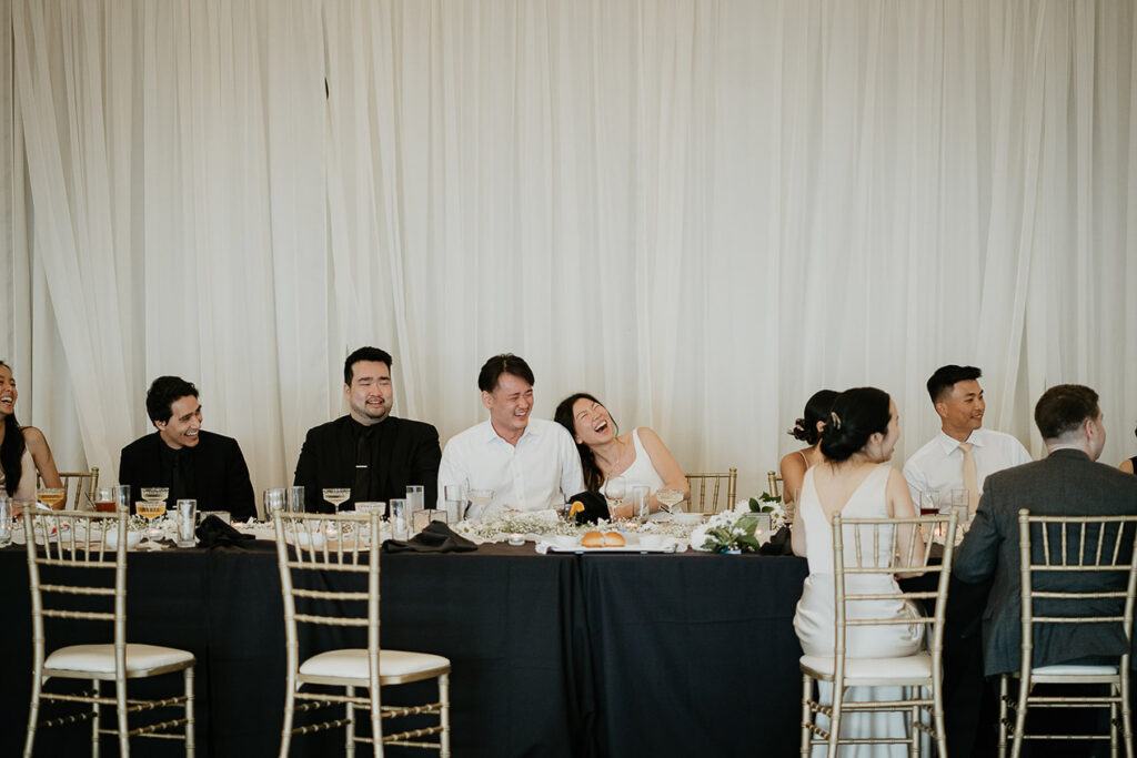 Judith and Joshua laughing during their wedding dinner. 