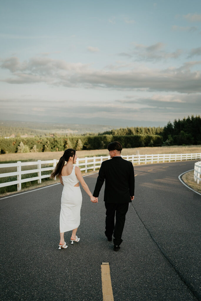 Joshua and Judith holding hands while walking along a road. 