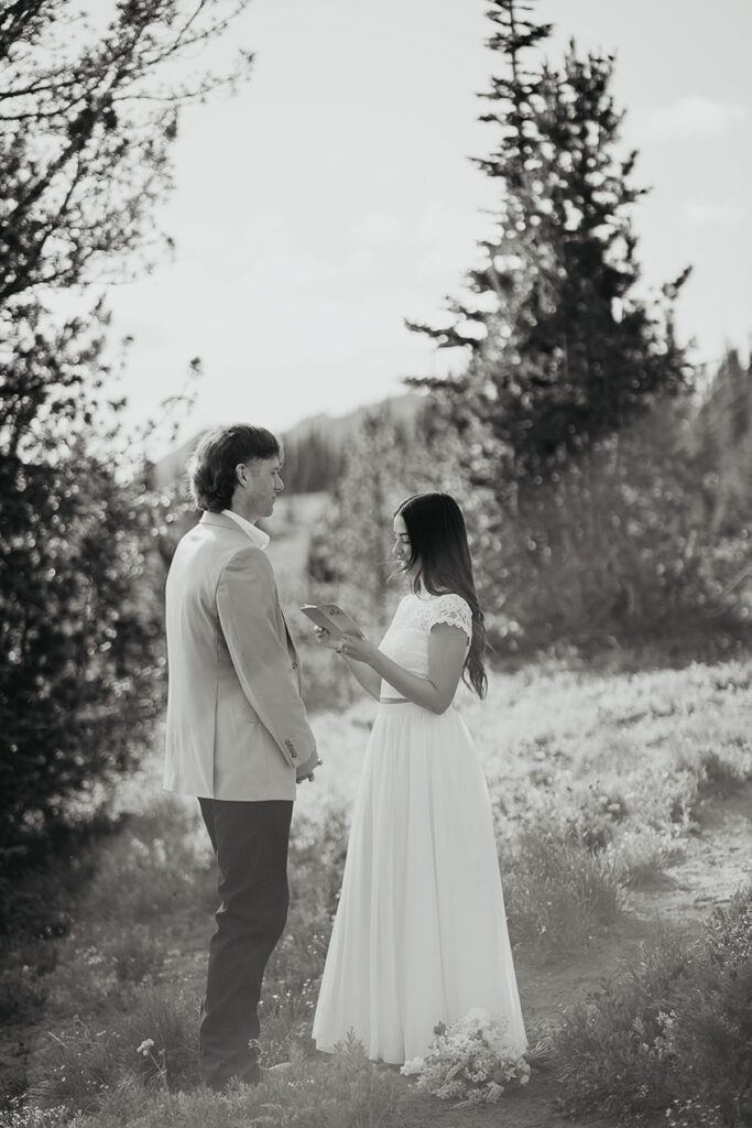 A black and white photo of the bride reading her vows. 