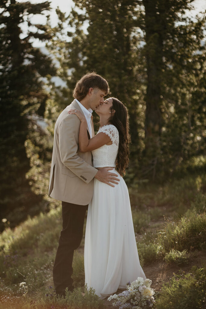 The couple kissing with the forest in the background. 