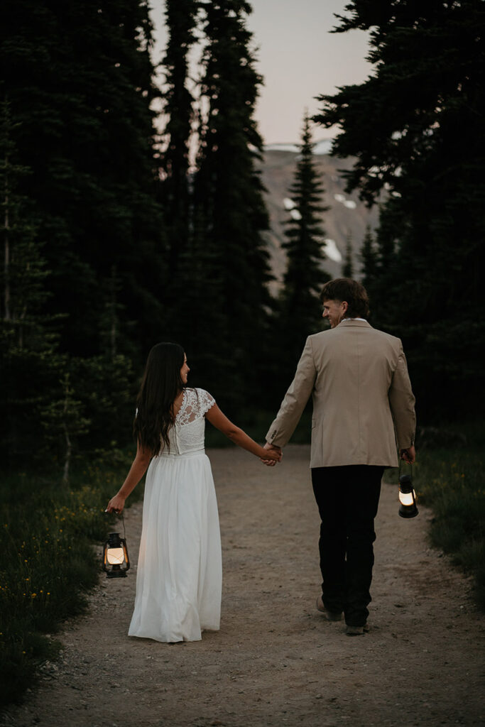 The couple holding hand and holding lanterns in the blue light.