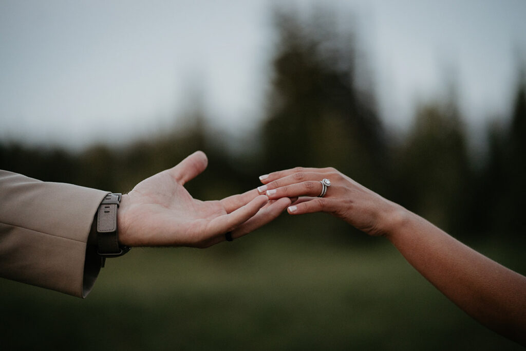 A close up on the husband, wife, and her ring. 