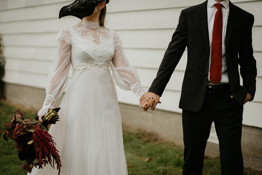 A couple holding hands in front of a chapel. 