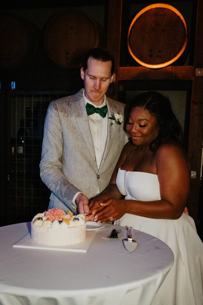 Bride and groom cut cake at their Washington winery wedding at Gorge Crest Vineyards