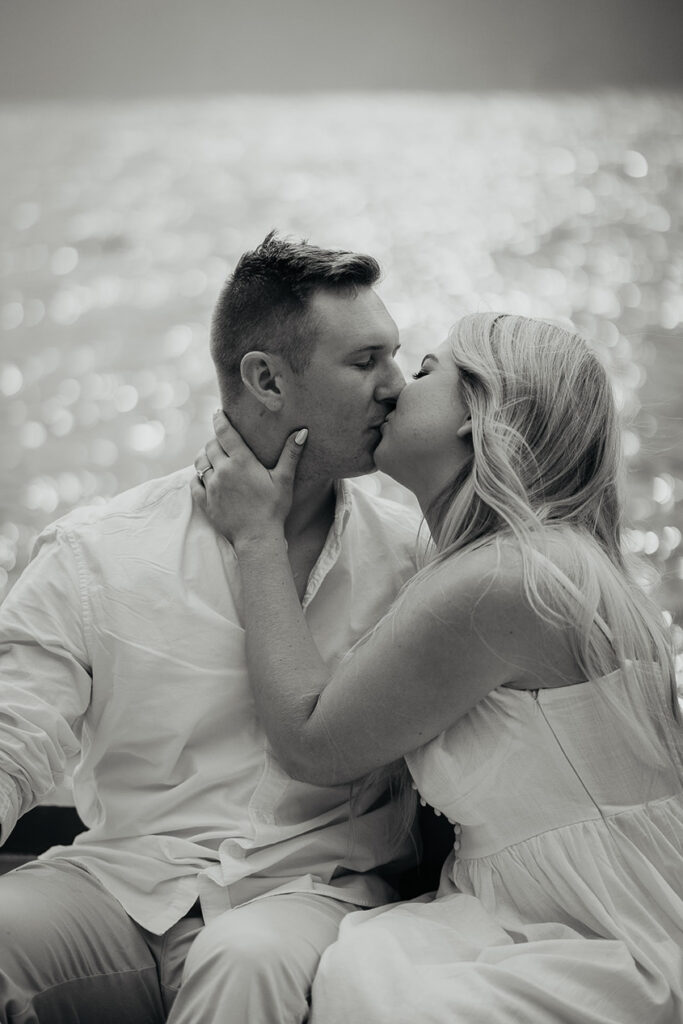 A couple kissing on a row boat. 