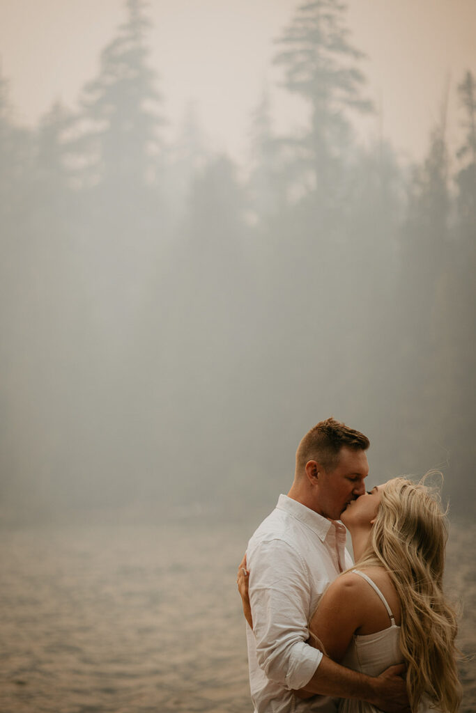 A couple kissing while standing on a row boat in Lost Lake. 