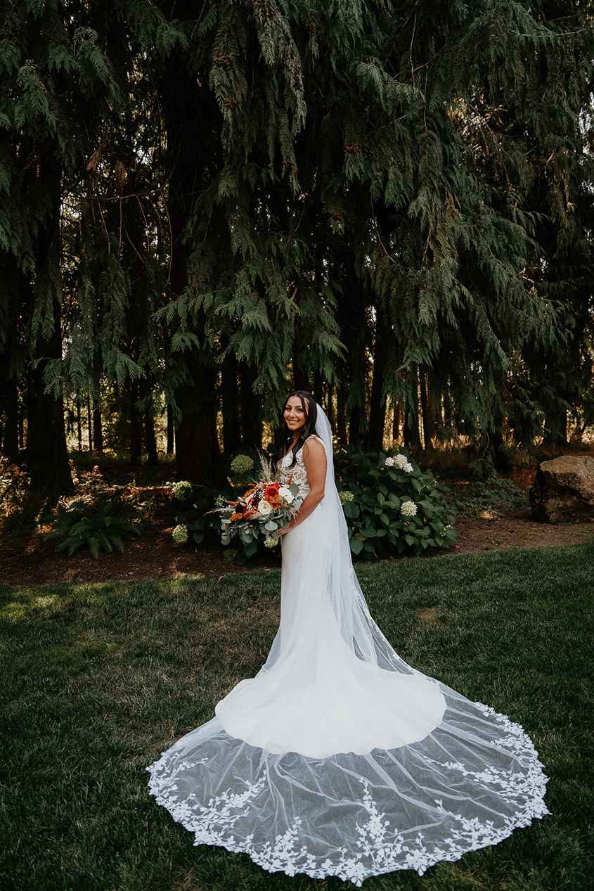 One of the brides holding flowers in a white wedding dress.  