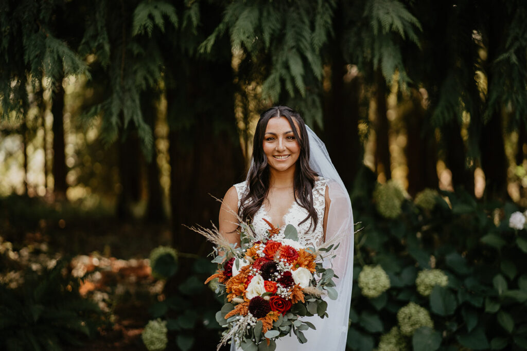 One of the brides holding flowers in a white wedding dress.  