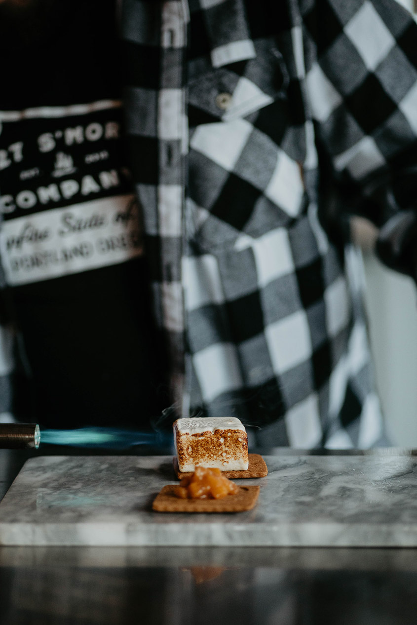 A marshmallow being blowtorched in the process of making a s'more. 