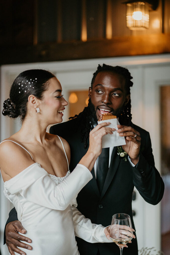 The bride and groom eating a s'more. 