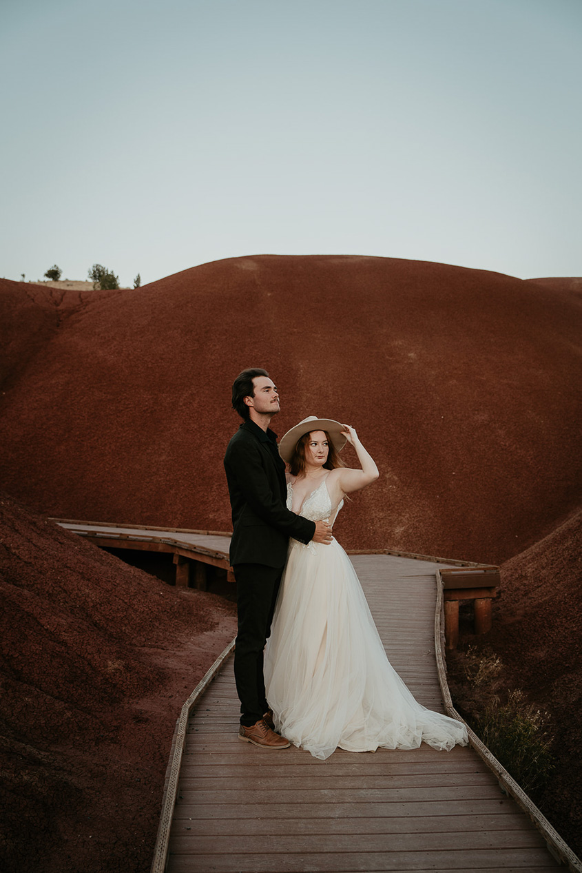 newlyweds walking the on a trail at Painted Hills