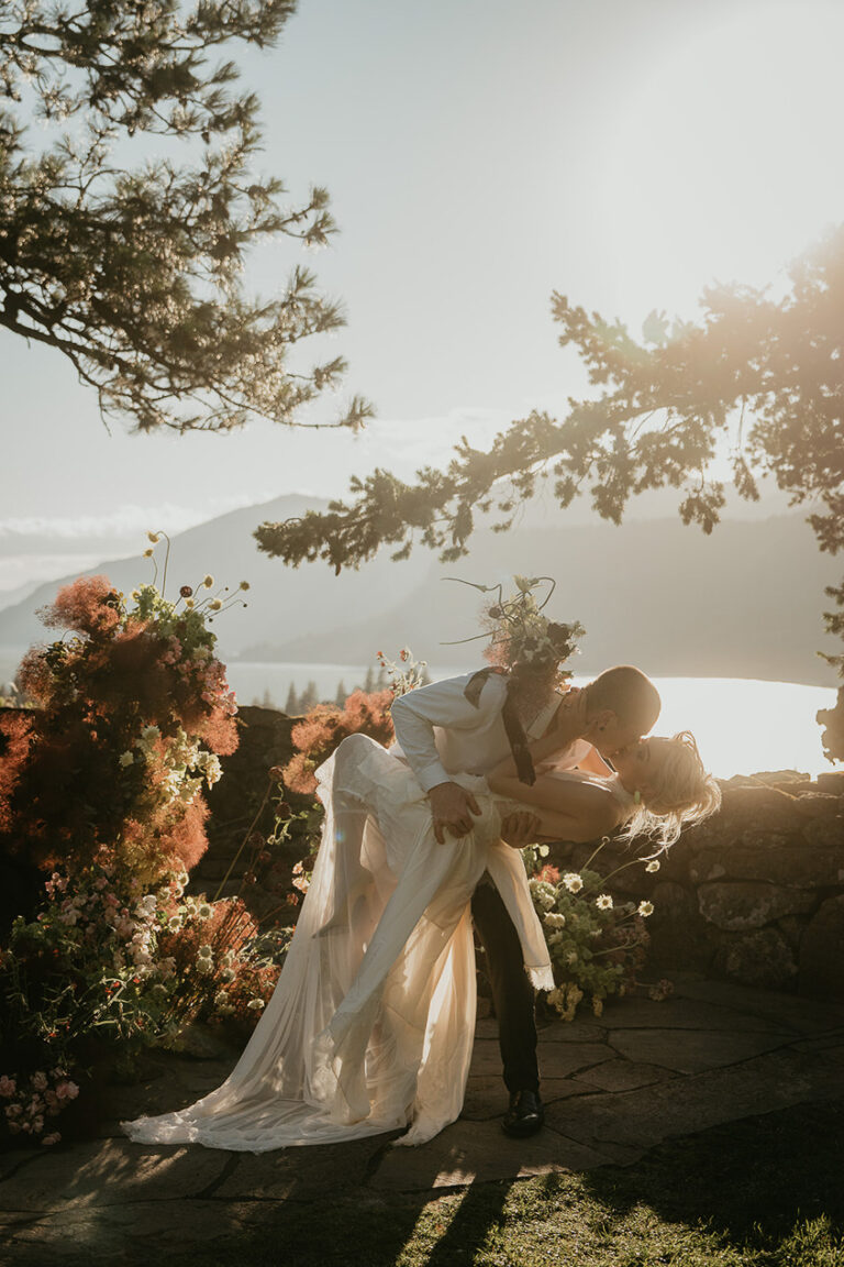 newlyweds kissing on a terrace above the Columbia River Gorge.