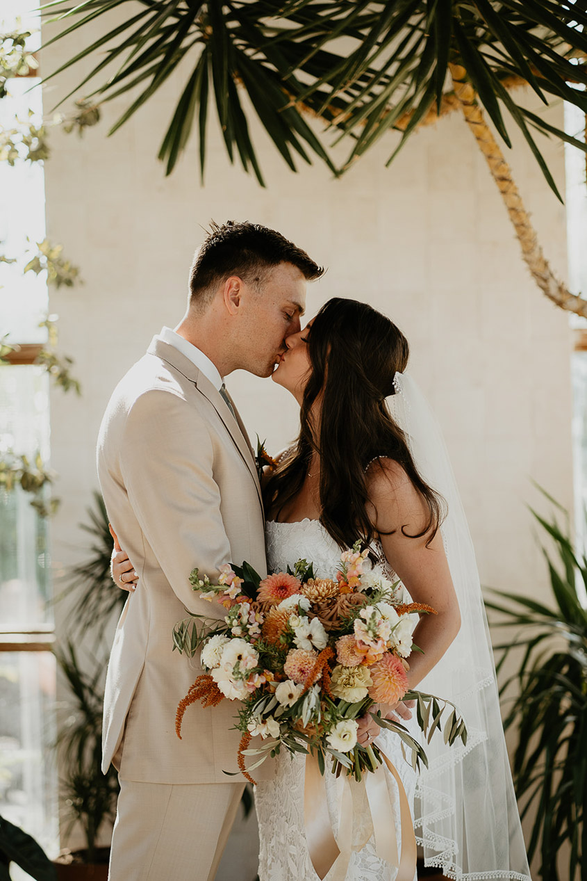 the bride and groom kissing at the alter.