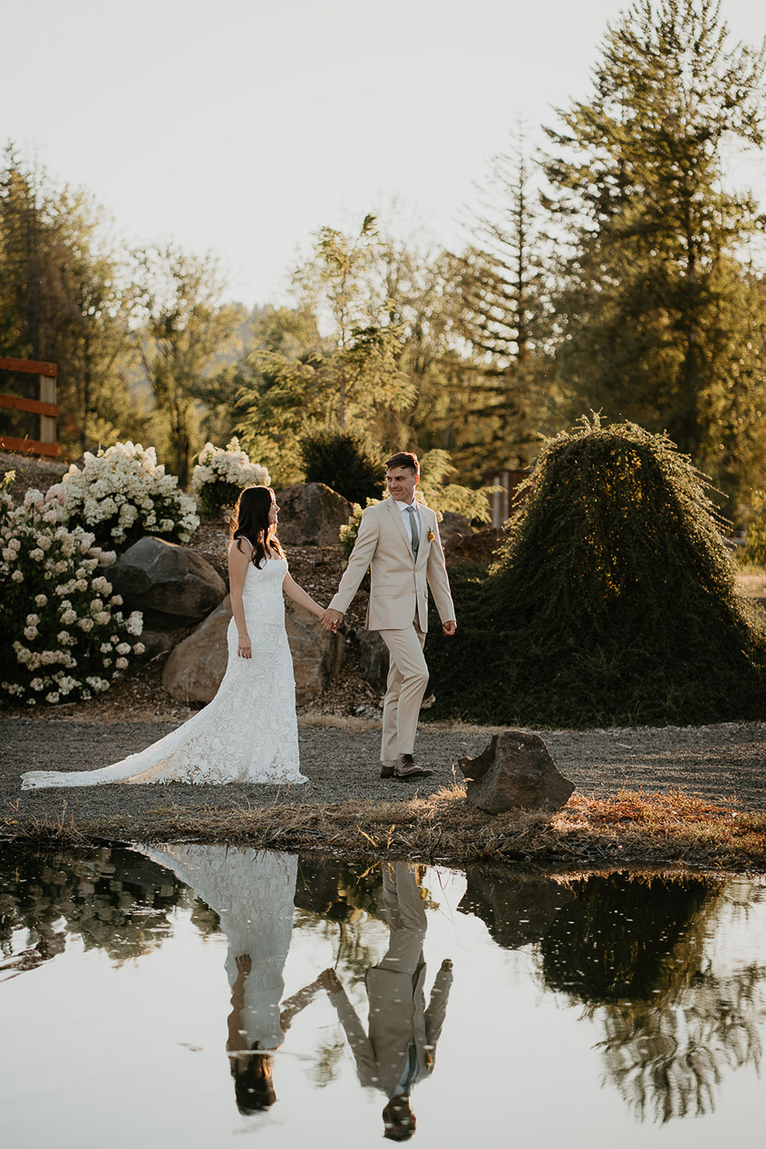 the newlyweds walking through a field at golden hour. 