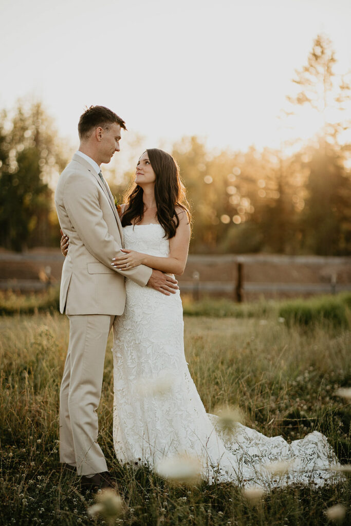 the newlyweds staring lovingly into each other's eyes while standing in a field.