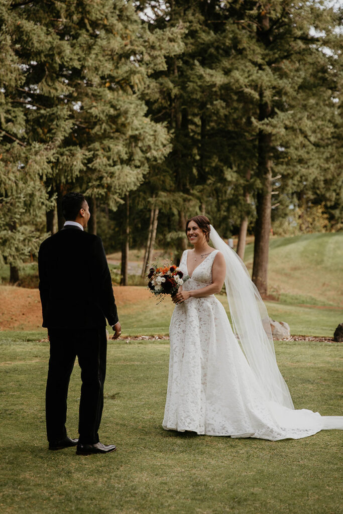 the groom smiling seeing the bride for the first time in her wedding dress. 