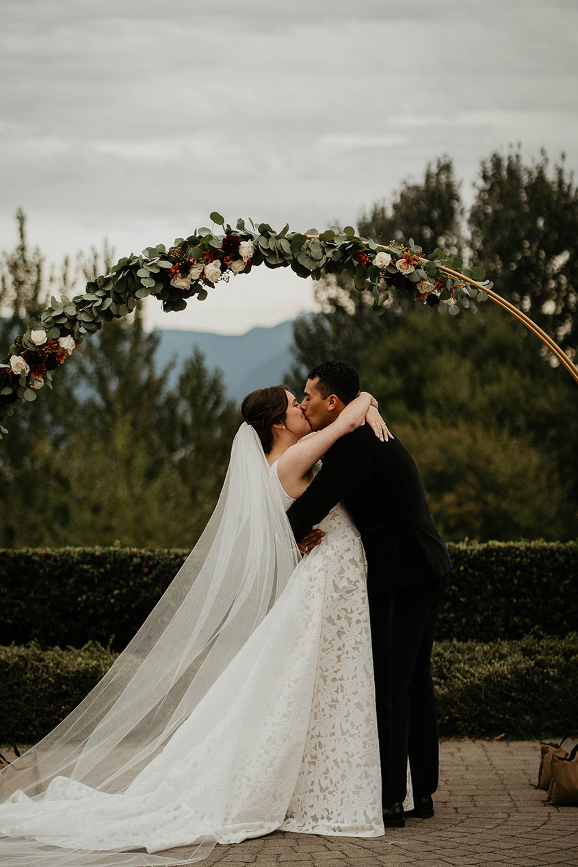 the bride and groom kissing at the alter. 