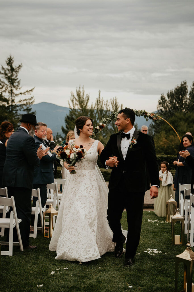 the bride and groom walking down the isle after getting married. 