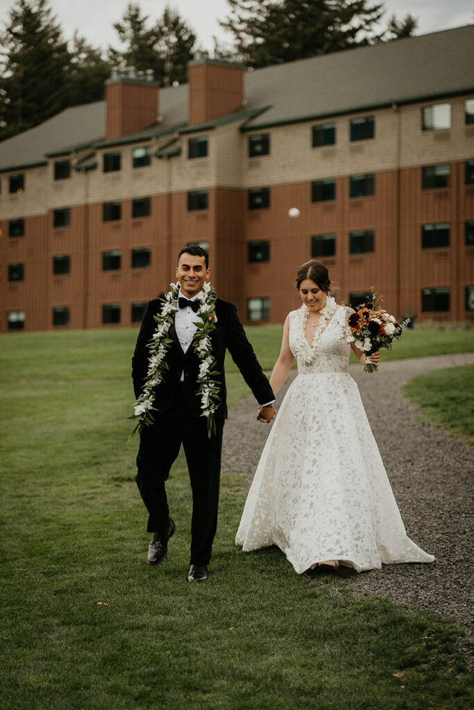 the newlyweds waking along a grassy field at Skamania Lodge.