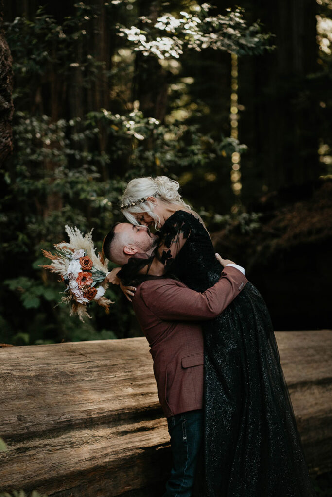 the newlyweds hugging each other in the middle of the forest. 