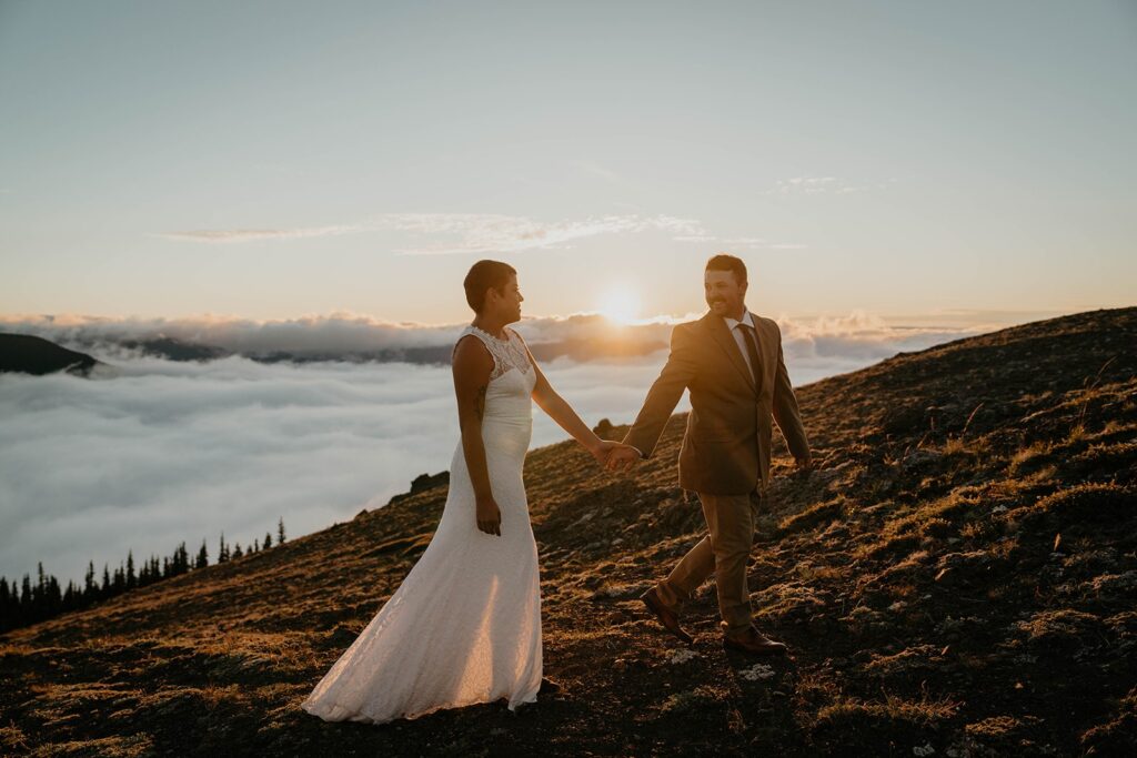 Bride and groom hold hands while walking around Hurricane Ridge at their Washington elopement