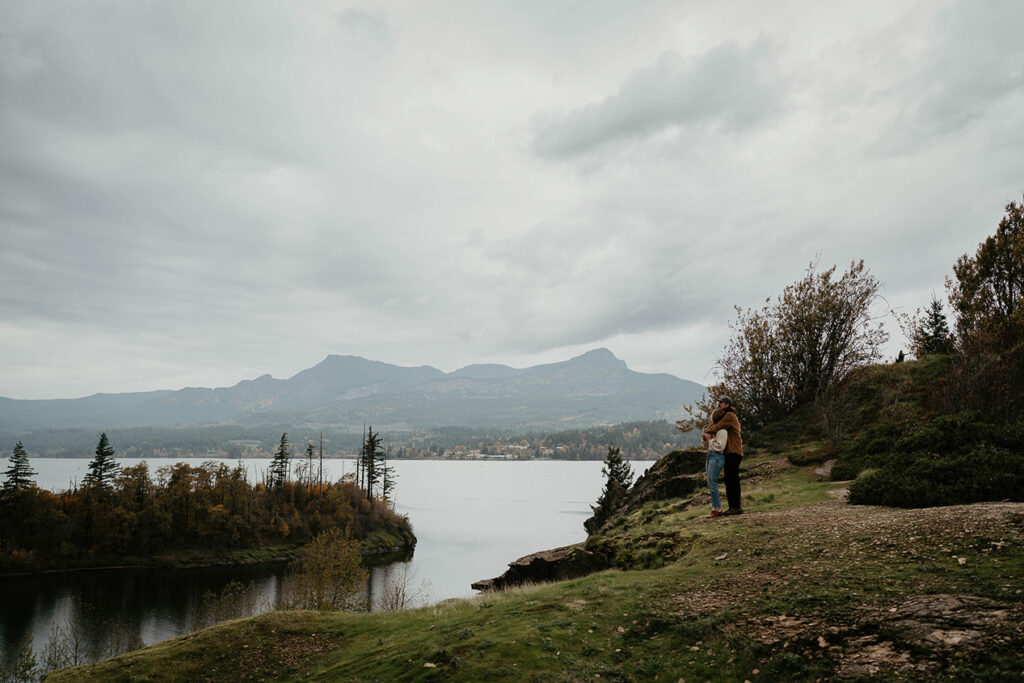 a couple embracing each other on the bank of the Columbia river. 