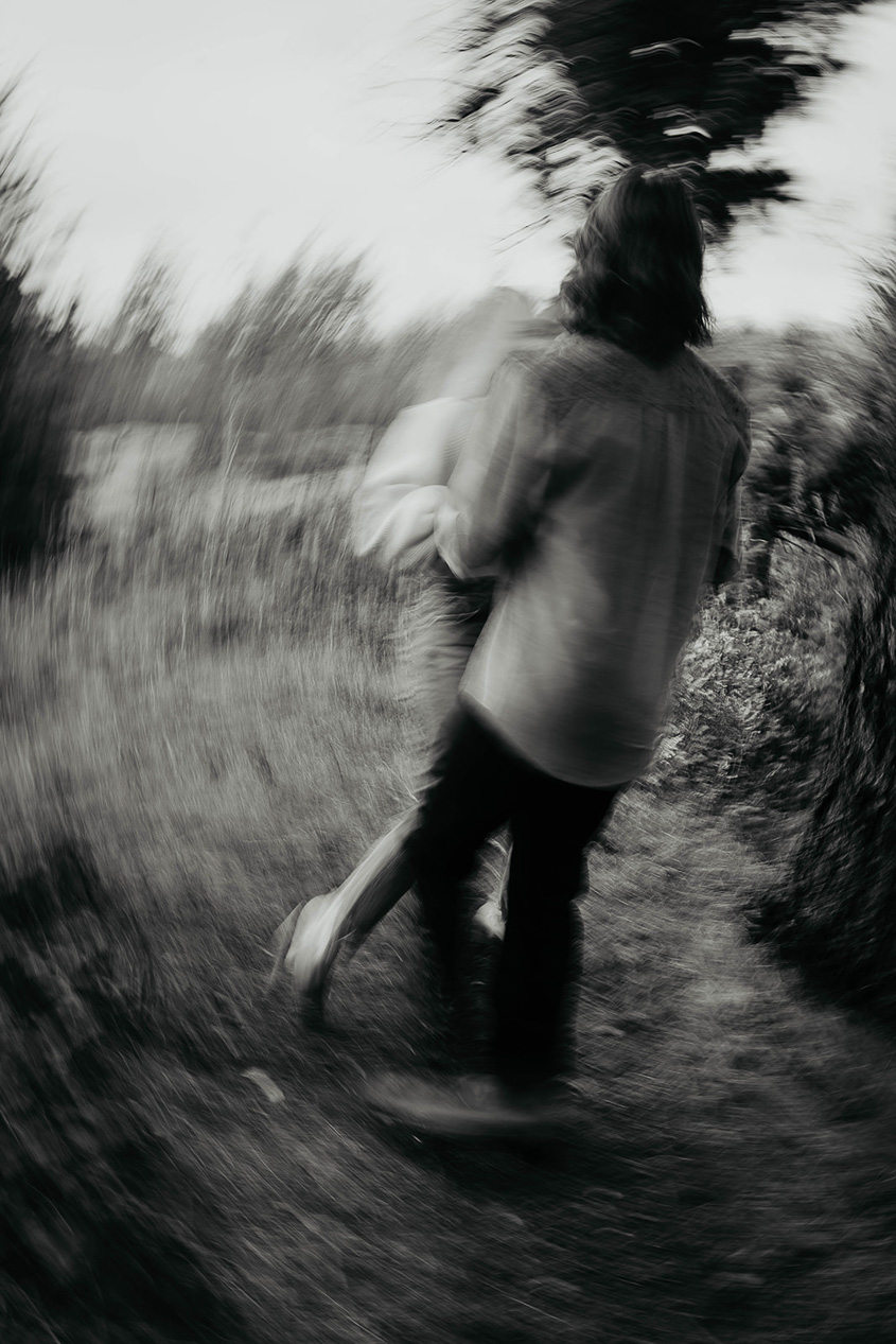 a blurry photo of a newly engaged couple dancing in nature. 