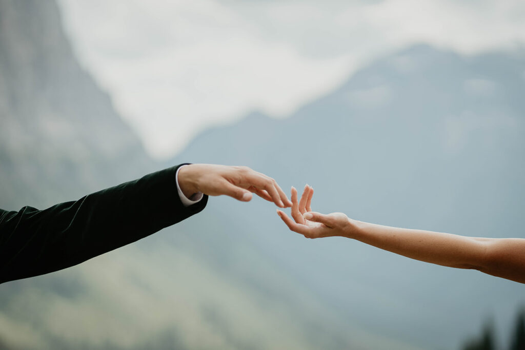 The bride and groom's hands almost touching. 