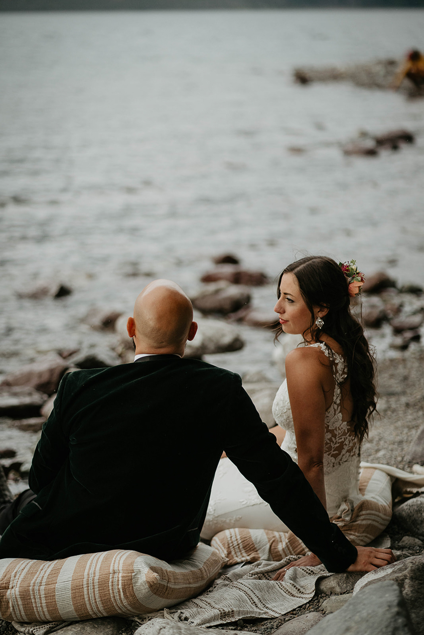 the couple having a picnic on the lakeshore during their Glacier National Park elopement. 