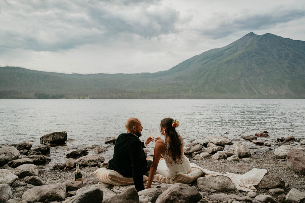 the couple having a picnic on the lakeshore during their Glacier National Park elopement. 