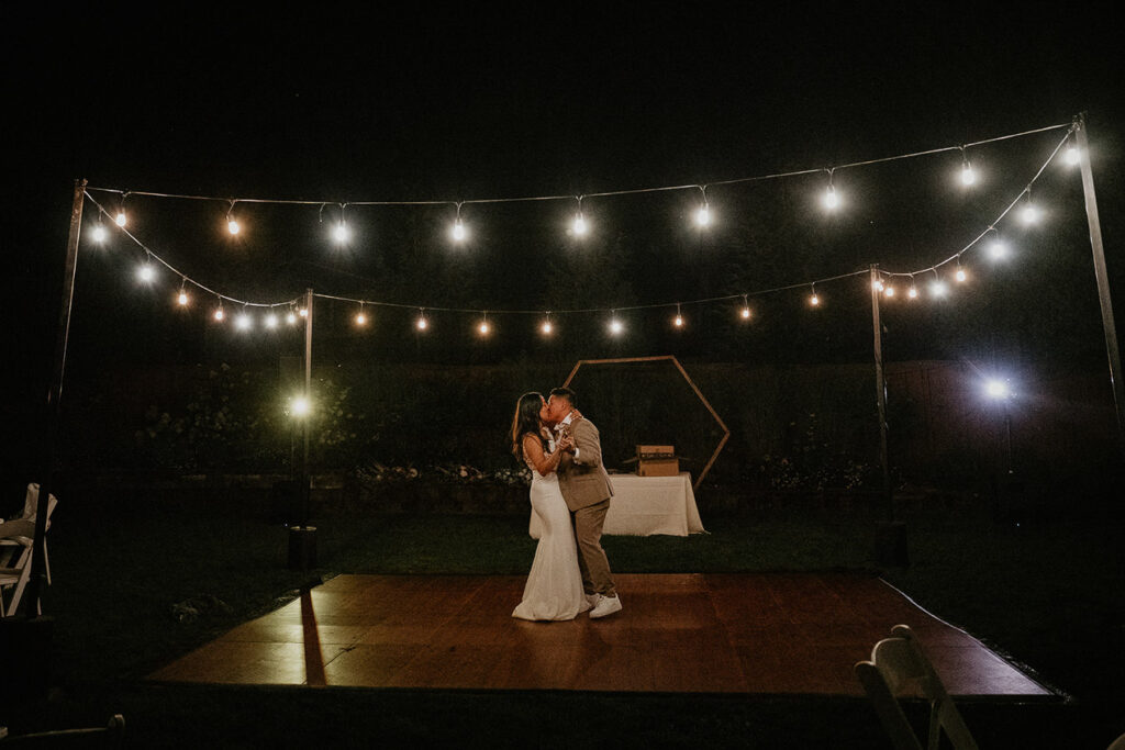 A newlywed couple dancing at night. 