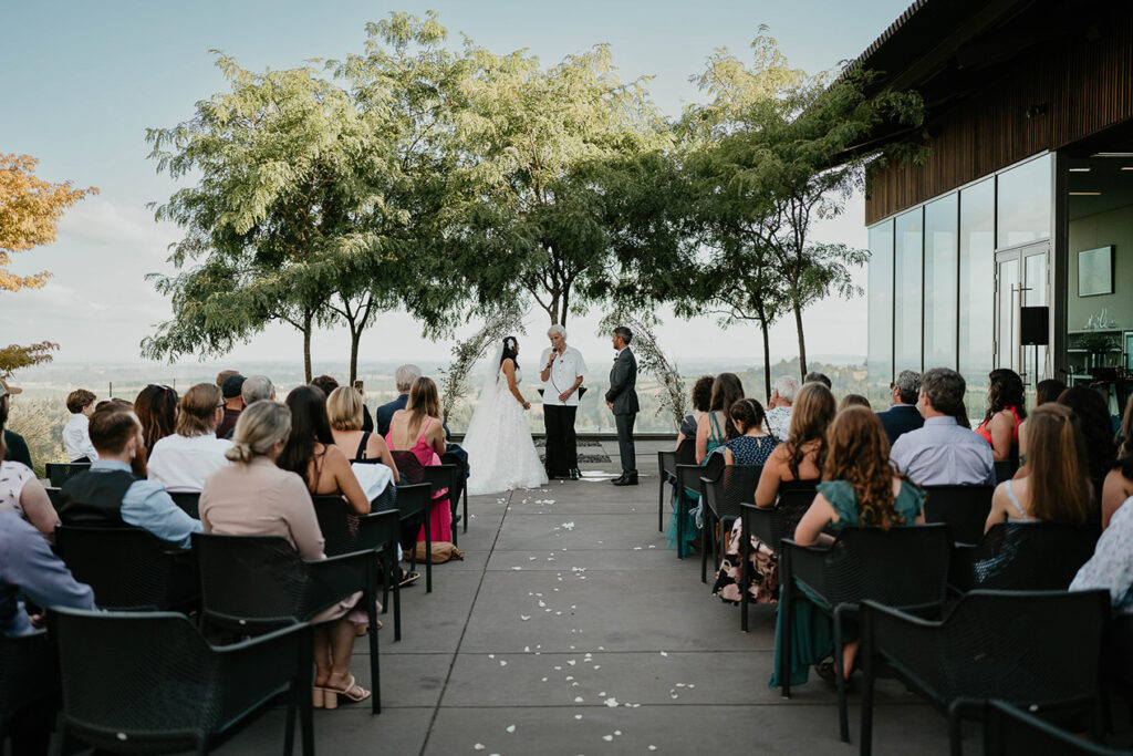 A couple at the alter with their friends and family in attendance. 