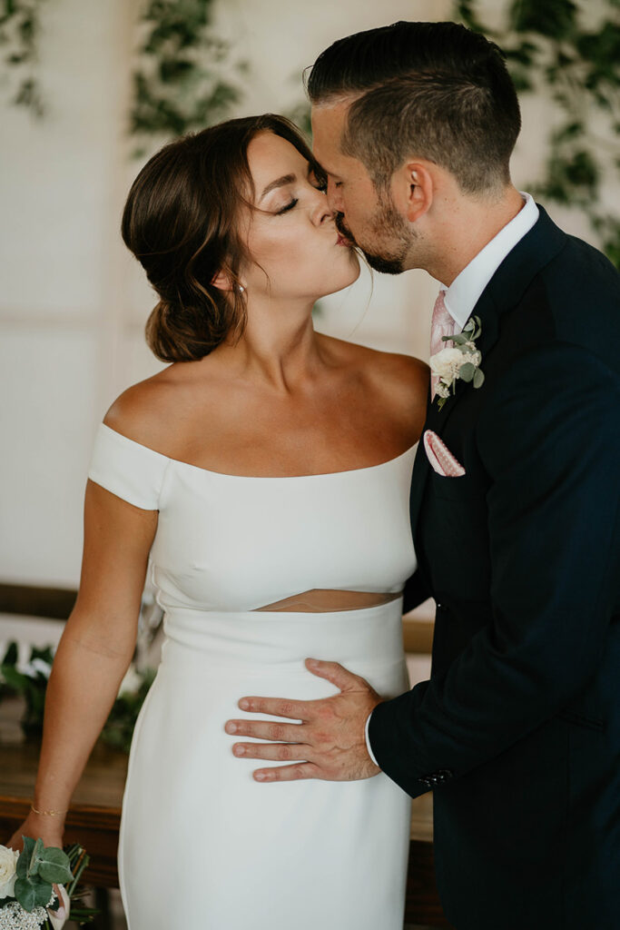 the bride and groom kissing. 