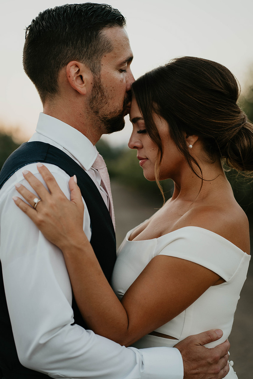 the groom kissing the bride's forehead. 