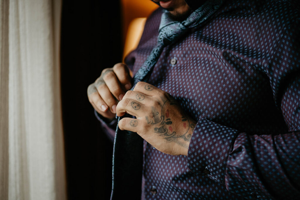 The groom adjusting his tie. 