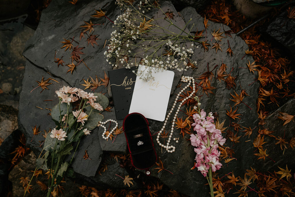 Wedding details, with pearls, flowers, rings, and wedding vows. 