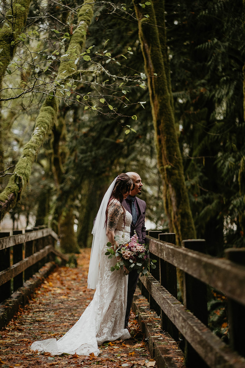 The bride and groom on a bridge looking at the view. 