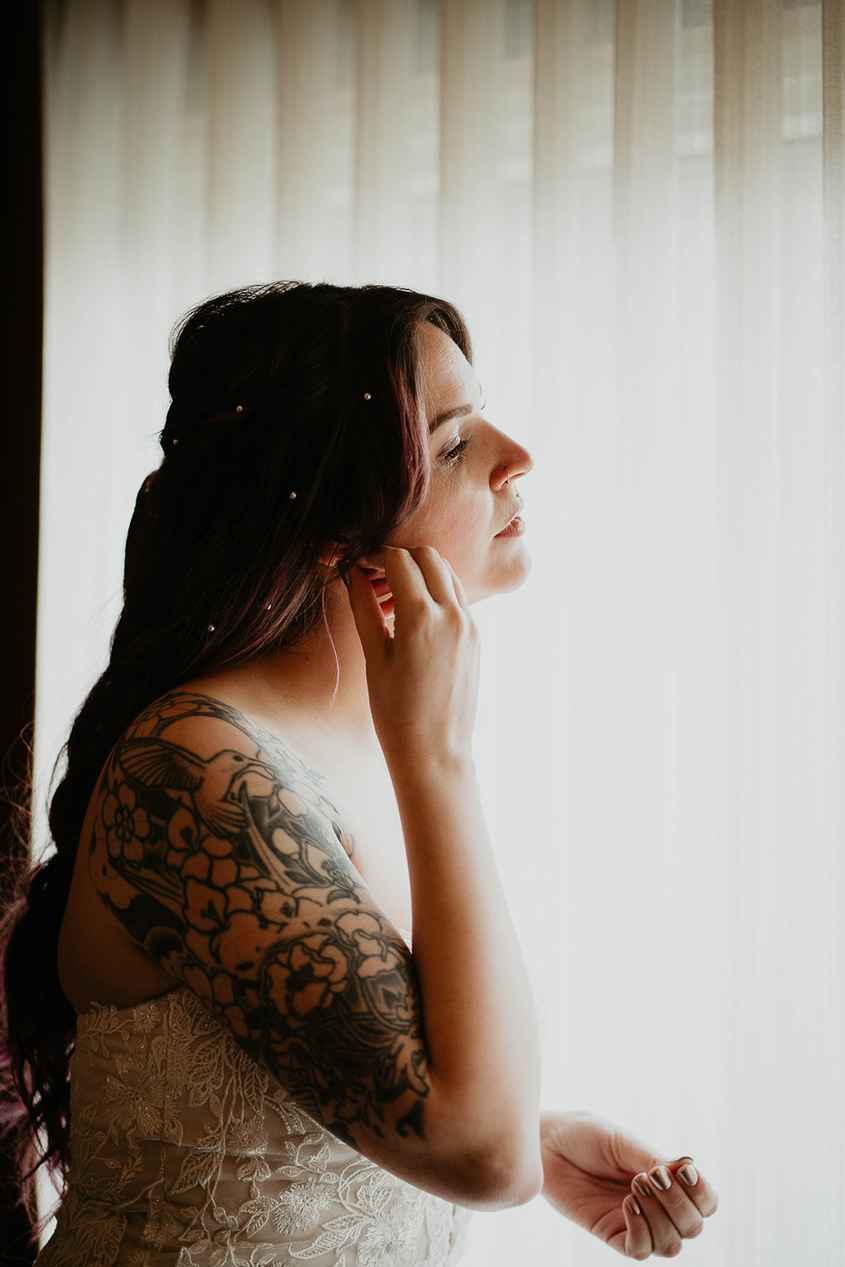 the bride adjusting an earring before her Lake Crescent elopement. 