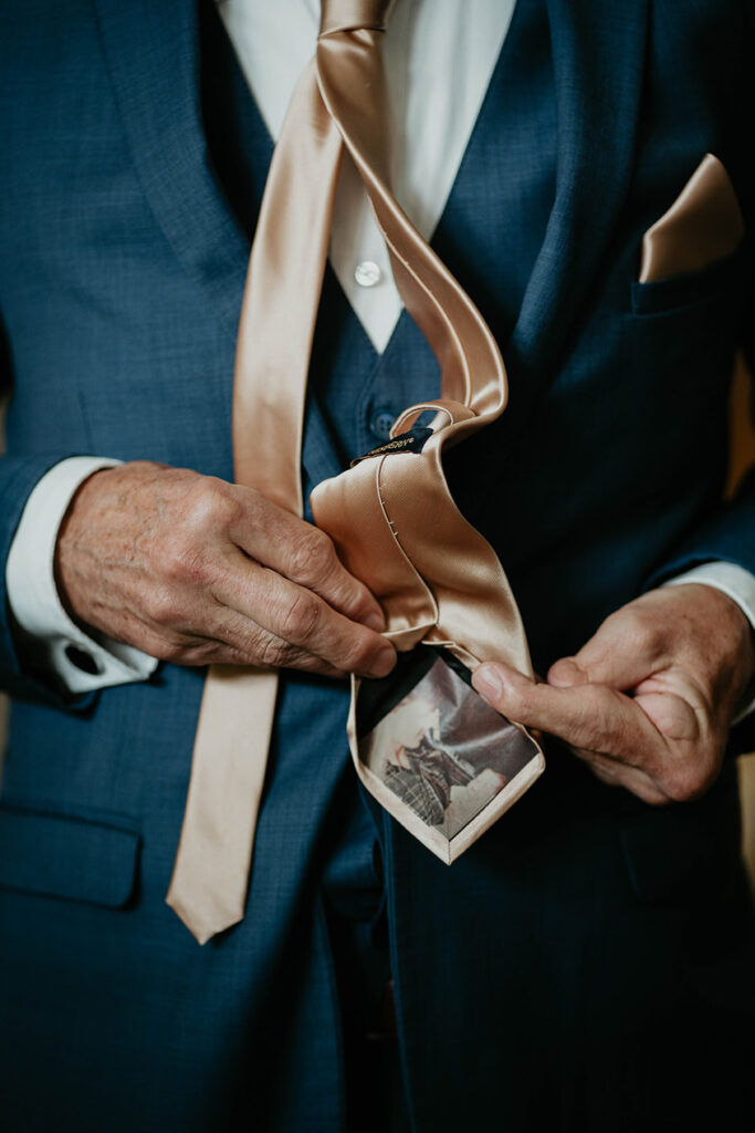 The groom adjusting his tie. 