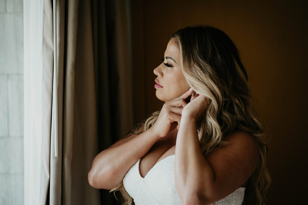 the bride adjusting an earing. 