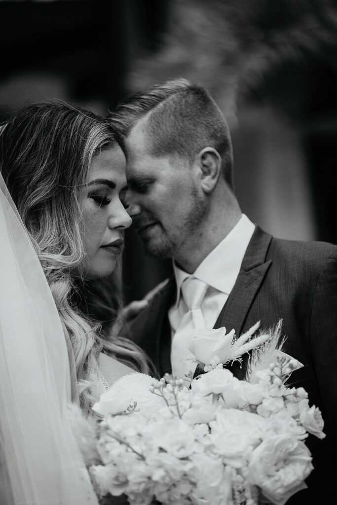 The bride and groom leaning on each other. 