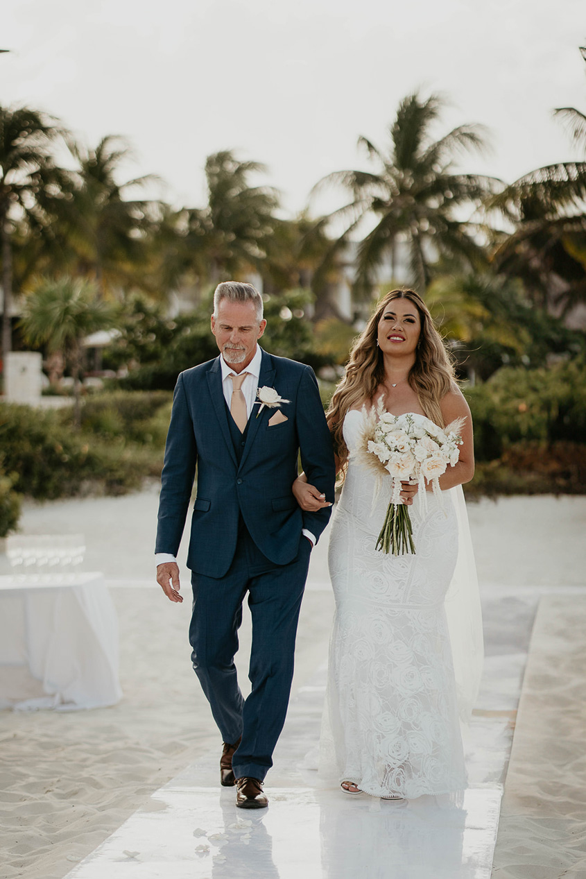 The bride getting walked down the isle by her father at her Mexico destination wedding.