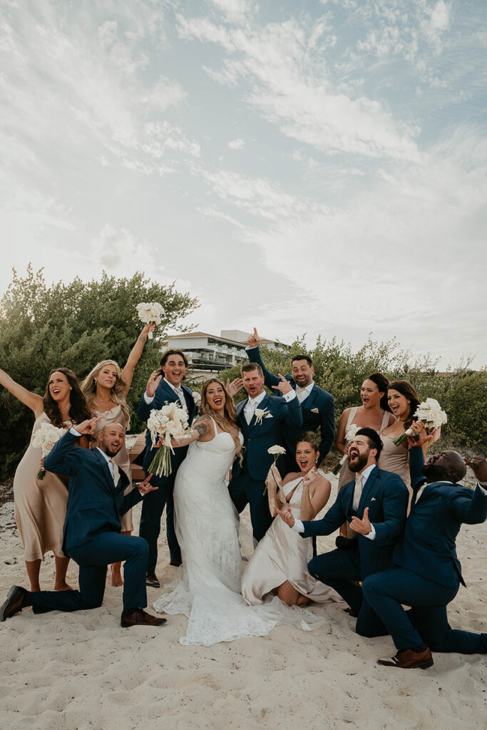 The bride and groom celebrating surrounded by their wedding party. 