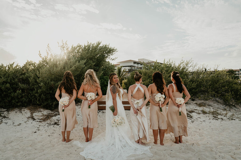 The bride and her bridesmaids holding white roses. 